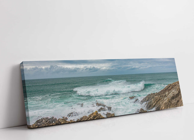 Breaking wave on the rocky Cornish coast. Panoramic Canvas picture print.